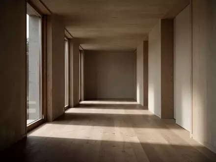 Ein leerer, sonnendurchfluteter Flur mit minimalistischer Architektur, der Raum für Reflexion und innere Ruhe symbolisiert. - Foto: über boerse-global.de