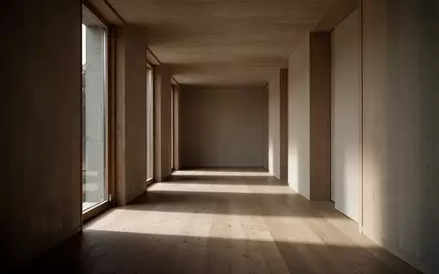 Ein leerer, sonnendurchfluteter Flur mit minimalistischer Architektur, der Raum für Reflexion und innere Ruhe symbolisiert. - Foto: über boerse-global.de
