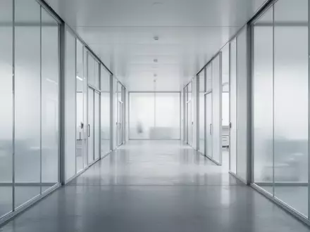 Ein minimalistischer, moderner Flur in einem Forschungsgebäude mit klaren architektonischen Linien und diffusem Licht. - Foto: über boerse-global.de