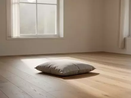 Ein minimalistischer, lichtdurchfluteter Raum mit einem einzelnen Meditationskissen auf einem Holzboden. - Foto: über boerse-global.de