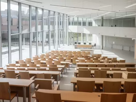 Ein minimalistisch gestalteter Hörsaal in einer modernen Universität mit hellem Holz und einfallendem Tageslicht. - Foto: über boerse-global.de