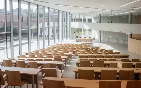 Ein minimalistisch gestalteter Hörsaal in einer modernen Universität mit hellem Holz und einfallendem Tageslicht. - Foto: über boerse-global.de