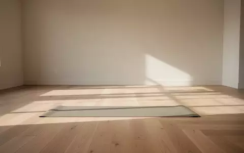 Ein minimalistischer, sonnendurchfluteter Yogaraum mit einer einzelnen Matte auf einem hellen Holzboden. - Foto: ĂĽber boerse-global.de