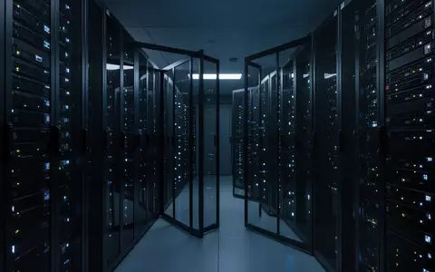 Ein moderner, minimalistischer Serverraum bei Nacht mit blau beleuchteten Metall-Serverracks in einer sauberen, professionellen Umgebung. - Foto: über boerse-global.de