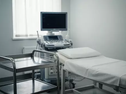 Ein steriler Behandlungsraum in einer Klinik mit einer medizinischen Untersuchungsliege und diagnostischen Geräten. - Foto: über boerse-global.de