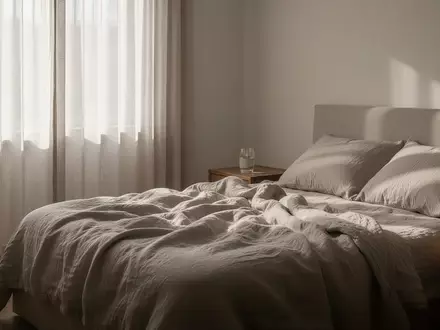 Ein ruhiges, minimalistisches Schlafzimmer mit weichem Tageslicht und einem ungemachten Bett. - Foto: über boerse-global.de