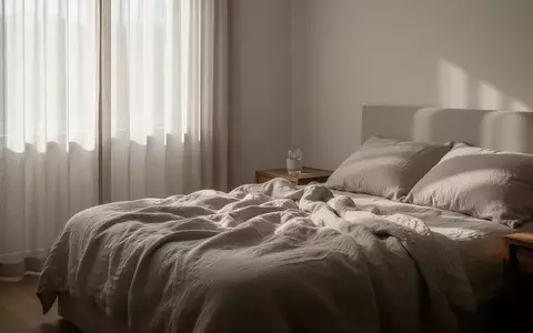 Ein ruhiges, minimalistisches Schlafzimmer mit weichem Tageslicht und einem ungemachten Bett. - Foto: über boerse-global.de
