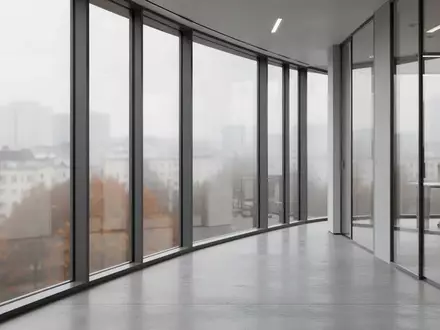 Ein leerer, modern gestalteter Büroflur mit großen Fensterfronten und Blick auf eine städtische Umgebung bei trübem Tageslicht. - Foto: über boerse-global.de