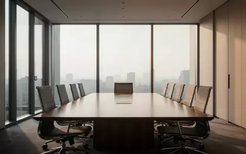 Ein leerer, modern eingerichteter Konferenzraum mit einem Holztisch und ergonomischen Stühlen bei natürlichem Tageslicht. - Foto: über boerse-global.de