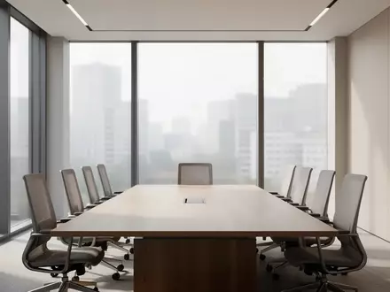 Ein moderner, leerer Konferenzraum mit einem langen Holztisch und ergonomischen Stühlen in einem hellen, architektonisch schlichten Ambiente. - Foto: über boerse-global.de