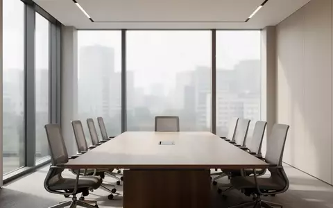 Ein moderner, leerer Konferenzraum mit einem langen Holztisch und ergonomischen Stühlen in einem hellen, architektonisch schlichten Ambiente. - Foto: über boerse-global.de