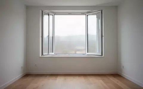 Ein offenes Fenster in einem minimalistischen, unmöblierten Raum mit hellem Holzboden und einfallendem Tageslicht. - Foto: über boerse-global.de