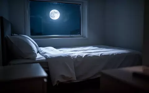 Ein minimalistisch eingerichtetes Schlafzimmer in der Nacht mit sanftem Mondlicht, das auf ein unbenutztes Bett fällt. - Foto: über boerse-global.de