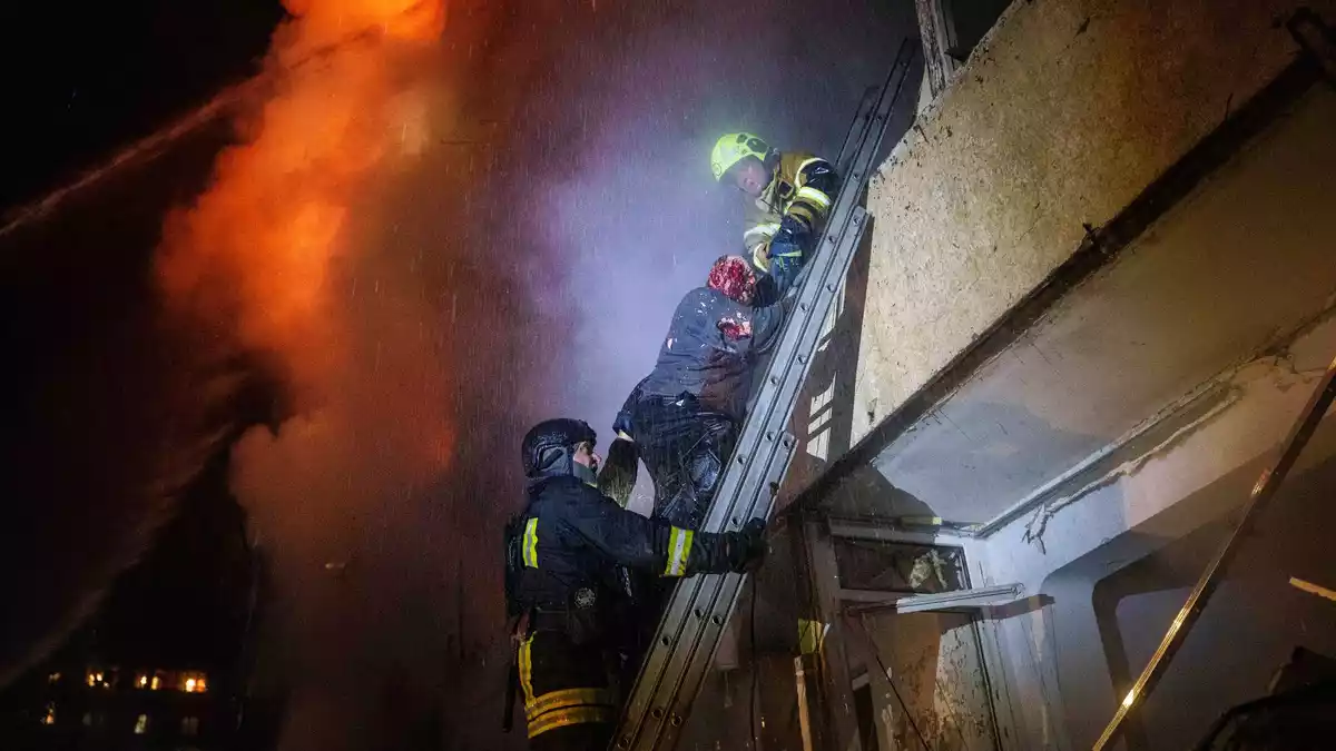 Rettungskräfte holten einen verletzten Hausbewohner aus seiner Wohnung. - Bild: Evgeniy Maloletka/AP/dpa