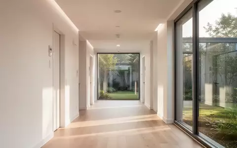Ein heller, moderner Flur in einer Pflegeeinrichtung mit großen Fenstern und Blick auf einen ruhigen Garten. - Foto: über boerse-global.de