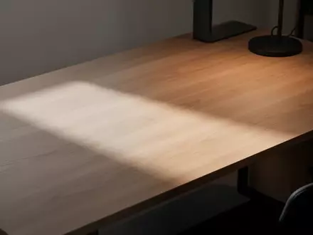 Ein minimalistischer Arbeitsplatz mit einem sauberen Schreibtisch aus Holz in einer ruhigen, professionellen Umgebung. - Foto: über boerse-global.de