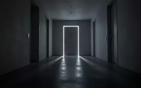 Ein schmaler, leerer Flur in einem modernen Wohngebäude bei Nacht mit langgezogenen Schatten und gedimmter Beleuchtung. - Foto: über boerse-global.de