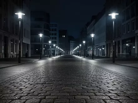 Eine leere, nächtliche Fußgängerzone mit Kopfsteinpflaster und moderner Architektur im Hintergrund. - Foto: über boerse-global.de