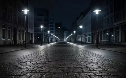 Eine leere, nächtliche Fußgängerzone mit Kopfsteinpflaster und moderner Architektur im Hintergrund. - Foto: über boerse-global.de