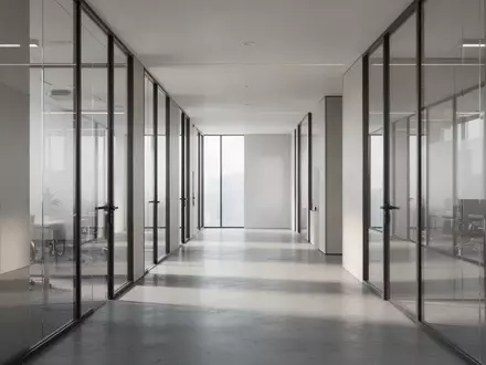Ein leerer, modern gestalteter Büroflur mit Glaswänden und natürlichem Lichteinfall. - Foto: über boerse-global.de