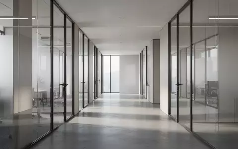 Ein leerer, modern gestalteter Büroflur mit Glaswänden und natürlichem Lichteinfall. - Foto: über boerse-global.de