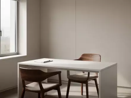 Ein minimalistischer, leerer Behandlungsraum in einer Arztpraxis mit hellem Tageslicht und einem schlichten Schreibtisch. - Foto: über boerse-global.de