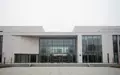Modernes Verwaltungsgebäude mit minimalistischer Architektur und Glasfassade bei bewölktem Himmel. - Foto: über boerse-global.de