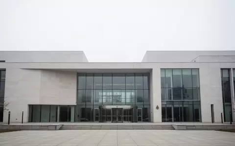 Modernes Verwaltungsgebäude mit minimalistischer Architektur und Glasfassade bei bewölktem Himmel. - Foto: über boerse-global.de