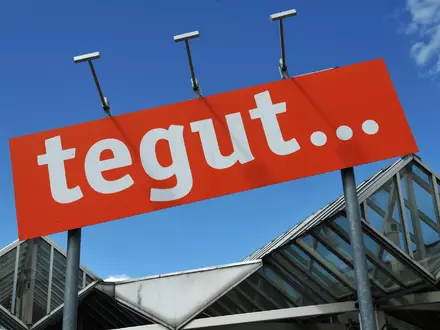 Das Tegut-Logo an einem Standort der Handelskette. - Foto: Uwe Zucchi/dpa