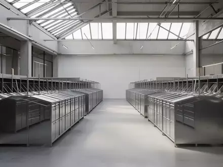 Leere Metallsortierbehälter in einer modernen, minimalistischen Postverteilzentrale bei natürlichem Lichteinfall. - Foto: über boerse-global.de