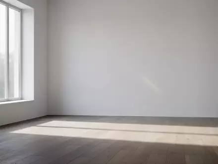 Ein minimalistischer, leerer Raum mit natürlichem Lichteinfall und sanften Schatten auf einem Holzboden. - Foto: über boerse-global.de