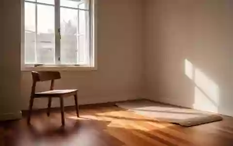 Ein minimalistischer Therapieraum mit hellem Tageslicht, Holzboden und einer Yogamatte. - Foto: über boerse-global.de