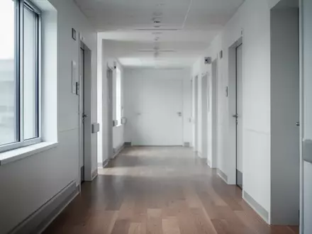 Ein heller, steriler Krankenhausflur mit modernem Design und natürlichem Lichteinfall ohne jegliche Beschilderung. - Foto: über boerse-global.de