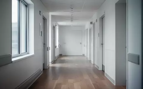Ein heller, steriler Krankenhausflur mit modernem Design und natürlichem Lichteinfall ohne jegliche Beschilderung. - Foto: über boerse-global.de