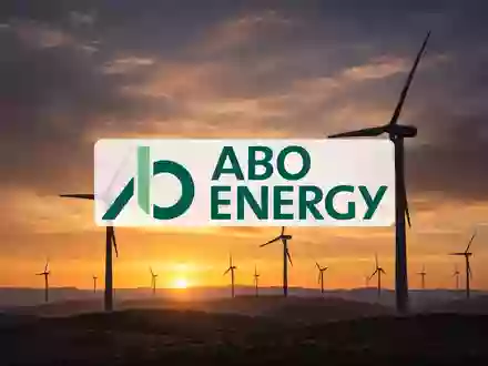 Moderne Windkraftanlagen in einer weitläufigen Landschaft bei Sonnenuntergang als Symbol für erneuerbare Energien. - Foto: über boerse-global.de