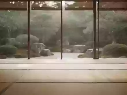 Ein ruhiger, minimalistischer Raum mit hellem Holzboden und Blick in einen japanischen Garten bei sanftem Tageslicht. - Foto: über boerse-global.de