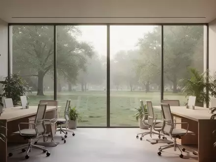 Ein heller, minimalistischer Büroraum mit großen Fenstern, Blick ins Grüne und einer ruhigen, entspannten Atmosphäre. - Foto: über boerse-global.de