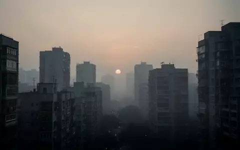 Dichte städtische Bebauung vor einem dunstigen, smogartigen Abendhimmel als Symbol für Umweltbelastungen. - Foto: über boerse-global.de