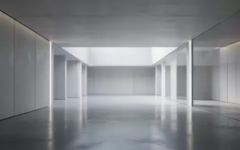 Ein minimalistisches, modernes Architekturinterieur mit klaren Linien und diffusem Licht, das auf polierten Betonböden reflektiert. - Foto: über boerse-global.de