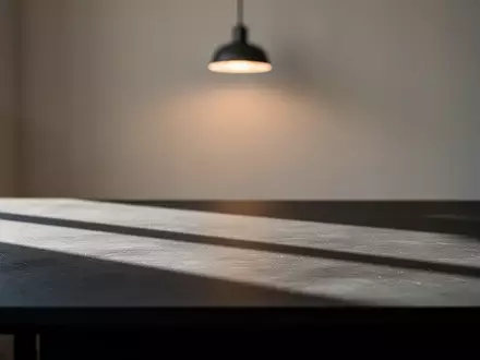 Ein minimalistischer Arbeitsplatz mit dunkler Schreibtischoberfläche und weichem, natürlichem Licht. - Foto: über boerse-global.de