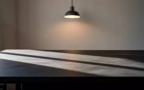 Ein minimalistischer Arbeitsplatz mit dunkler Schreibtischoberfläche und weichem, natürlichem Licht. - Foto: über boerse-global.de