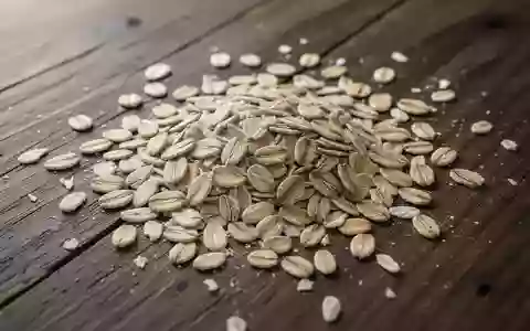 Nahaufnahme von rohen Haferflocken, die auf einem dunklen Holztisch verstreut liegen. - Foto: über boerse-global.de