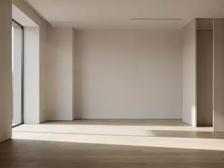 Ein lichtdurchfluteter, leerer Arbeitsraum mit minimalistischer Architektur und sanftem Lichteinfall auf einem Holzboden. - Foto: über boerse-global.de