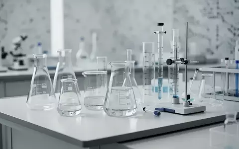 Ein minimalistischer, steriler Labortisch mit wissenschaftlichen Glasgefäßen in einer klinischen Forschungsumgebung. - Foto: über boerse-global.de