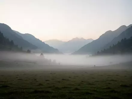 Eine neblige, stille Gebirgslandschaft in der Morgendämmerung, die Ruhe und Abgeschiedenheit symbolisiert. - Foto: über boerse-global.de