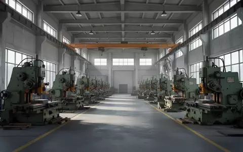 Leere, moderne Industriehalle mit schweren Fertigungsmaschinen in einer hellen, weitläufigen Fabrikumgebung. - Foto: über boerse-global.de