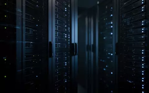 Ein minimalistischer, dunkel gehaltener Serverraum mit bläulicher Beleuchtung, der eine technologische Sicherheitsumgebung symbolisiert. - Foto: über boerse-global.de