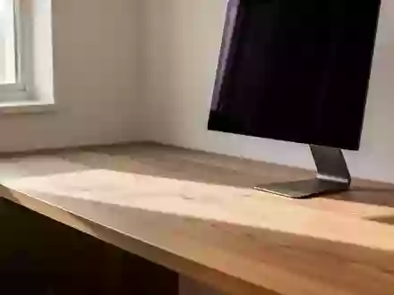 Ein minimalistischer, moderner Arbeitsplatz mit einem Eichenschreibtisch, der in natürlichem Licht liegt. - Foto: über boerse-global.de