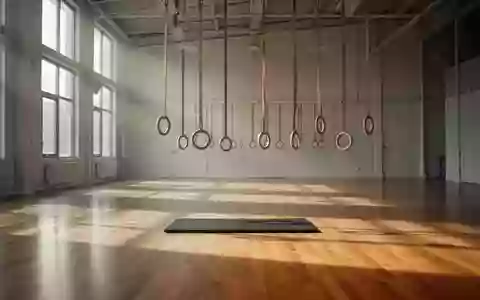 Leere, minimalistische Trainingshalle mit Holzboden und hängenden Gymnastikringen in ruhigem Licht. - Foto: über boerse-global.de
