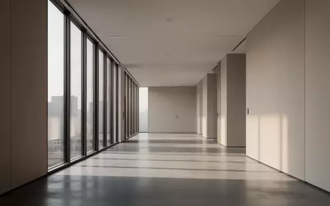 Ein minimalistischer Flur in einem modernen Bürogebäude mit hellem, natürlichem Tageslicht und klaren architektonischen Linien. - Foto: über boerse-global.de